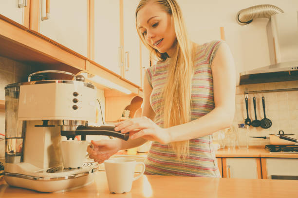 istock Woman in kitchen making coffee from machine 1181082289