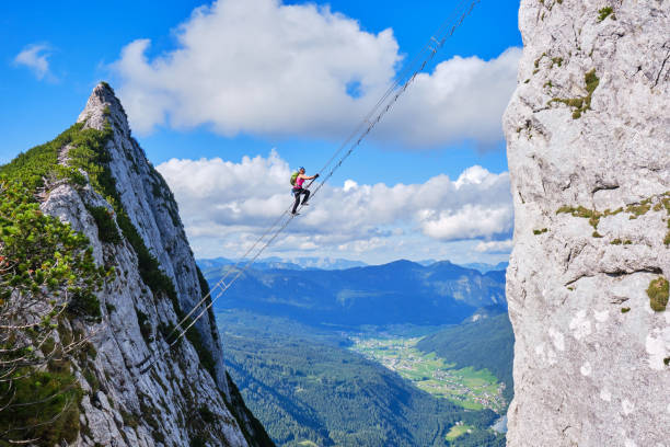 via ferrata donnerkogel intersport klettersteig in the austrian alps, near gosau. stairway to heaven concept. - climbing women sport mountain stock-fotos und bilder