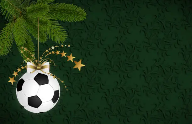 Soccer christmas bauble hanging on the fir branch. Christmas card with space for text
