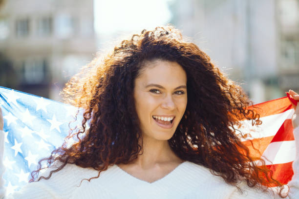 istock Young woman holding the American flag 1181091908
