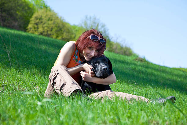 istock woman with black labrador on a green grass 118109706