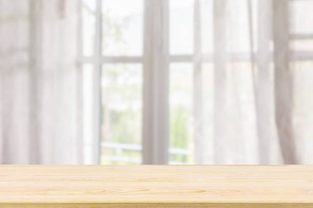 istock Empty wood table top with window curtain abstract blur background for product display 1181098796