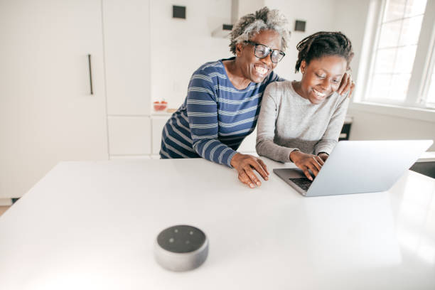 istock Grandma and granddaughter using laptop in the kitchen 1181098811