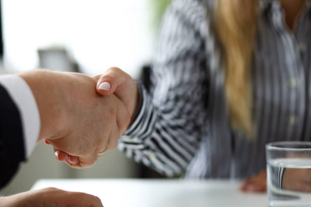 hombre y mujer dándose la mano después de deliberaciones productivas - mediación fotografías e imágenes de stock