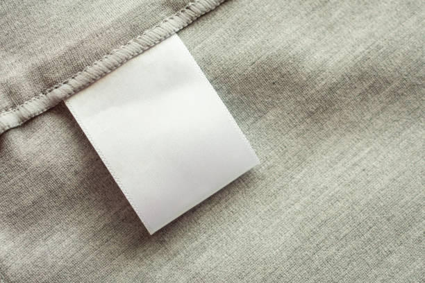 istock White blank laundry care clothing label on gray fabric texture background 1181099518