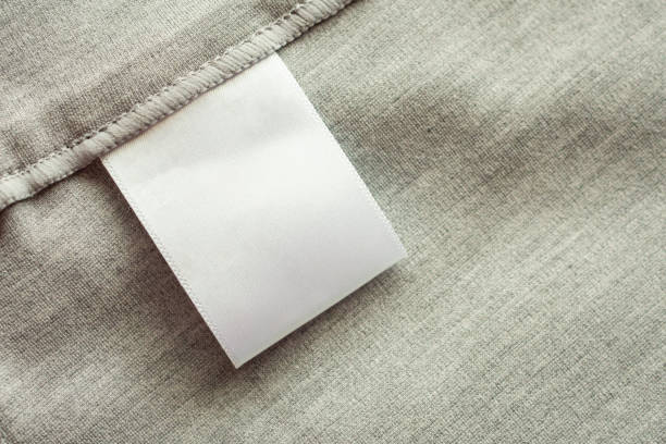 белый пустой прачечной одежды этикетки на серый фон текстуры ткани - label textile shirt stitch стоковые фото и изображения