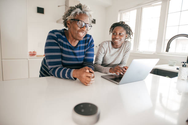 istock Grandma teaching granddaughter how to use speaker with online features 1181099892