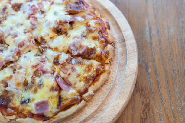 istock Closeup hot pizza slice with dripping ham sausage and mozzarella cheese. 1181100971