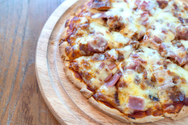 istock Closeup hot pizza slice with dripping ham sausage and mozzarella cheese. 1181100985