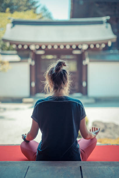 femme caucasien méditant dans le jardin de temple - zen like women temple meditating photos et images de collection