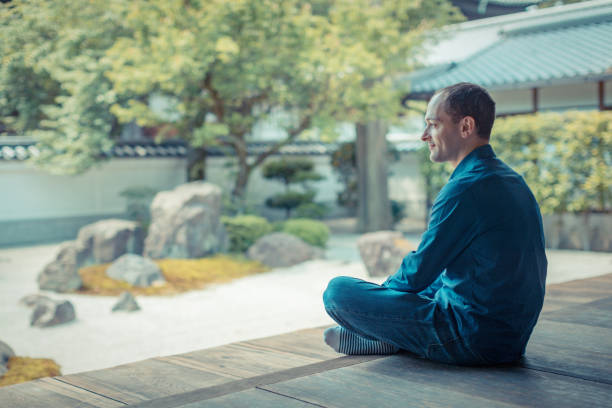 A white man is looking at the temple garden in Kyoto
