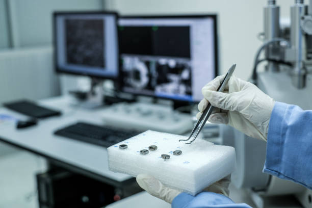 Scientist is preparation of nanomaterials for Scanning Electron Microscope (SEM) machine and blur computer controller background in laboratory stock photo