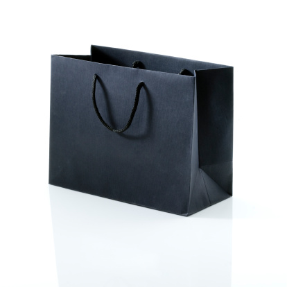 High-end fashion shopping bag on white background with reflection.