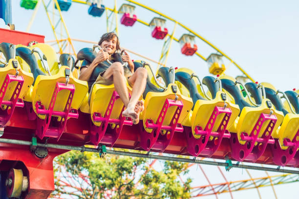 istock Beautiful, young man having fun at an amusement park 1181124415
