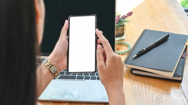 istock Closeup woman's holding smartphone with empty screen on office desk. 1181124561
