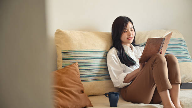 istock Young woman relaxing at home with reading a book. 1181124668
