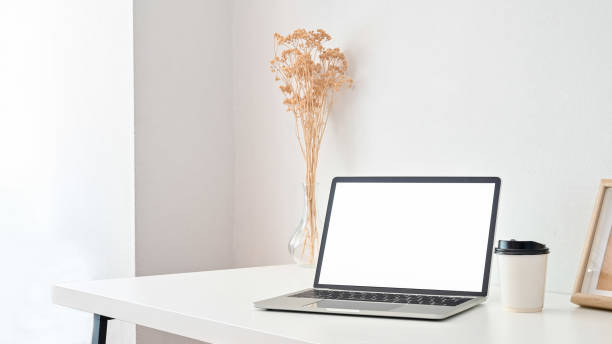 istock Workspace laptop computer, coffee and flower dry in vase on white table. 1181124832