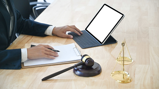 Cropped shot business lawyer working with paper and mockup tablet.