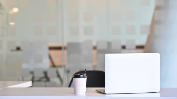 istock Workspace laptop computer and coffee paper cup on table front of meeting room. 1181124946