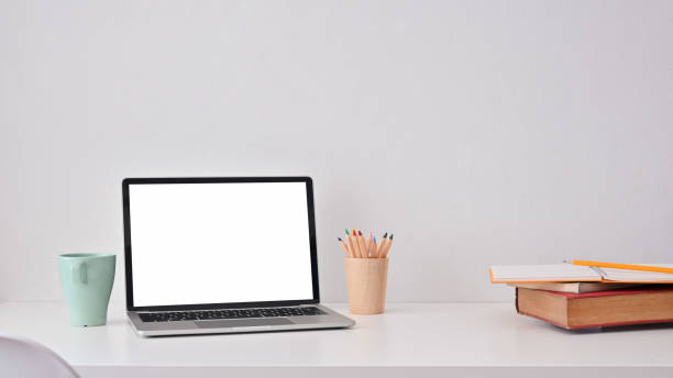 Creative workspace with laptop computer, books, colour pencil and coffee mug.