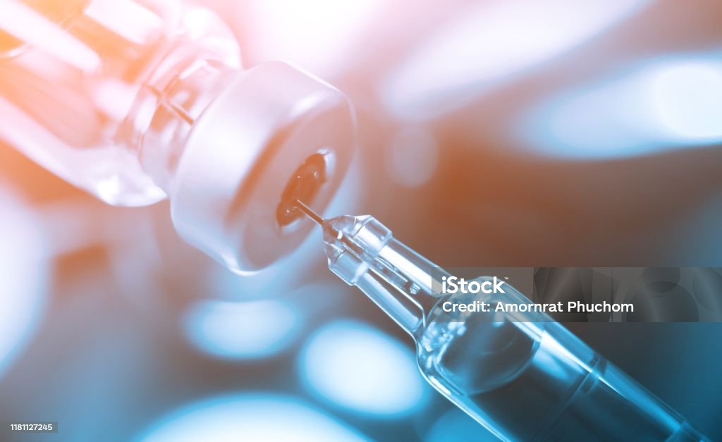 Vaccine vial dose flu shot drug needle syringe,medical concept vaccination hypodermic injection treatment disease care hospital prevention immunization illness disease  baby child.blue background IV Drip Stock Photo