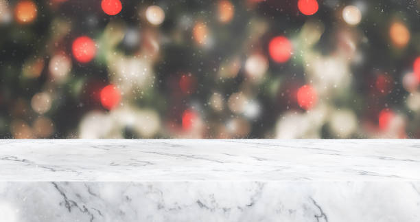 istock marble table top with abstract blur christmas tree red decor ball and snow fall background with bokeh light,winter Holiday backdrop,Mock up banner for display of product or promotion 1181131771