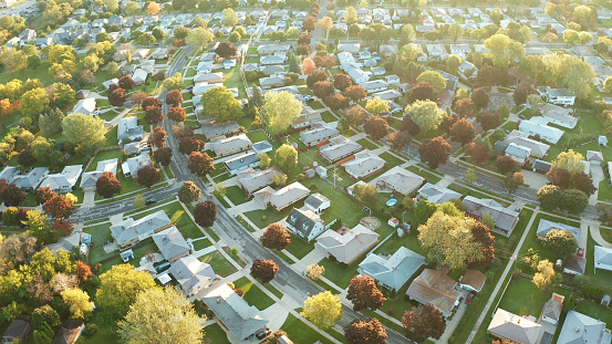 Vista aérea de casas residenciales en otoño (octubre). Barrio americano, suburbio. Bienes raíces, disparos de drones, puesta de sol, mañana soleada, luz solar, desde arriba photo