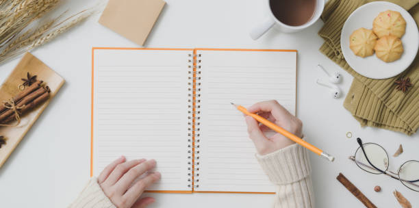 istock Top view of young female writing on notebook in autumn workspace 1181134814