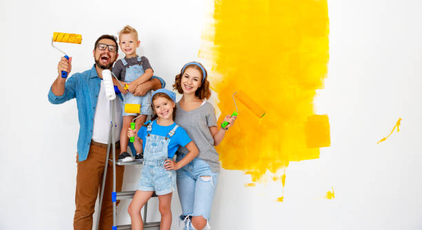 repair in apartment. happy family mother, father and children   paints wall - 12023 imagens e fotografias de stock