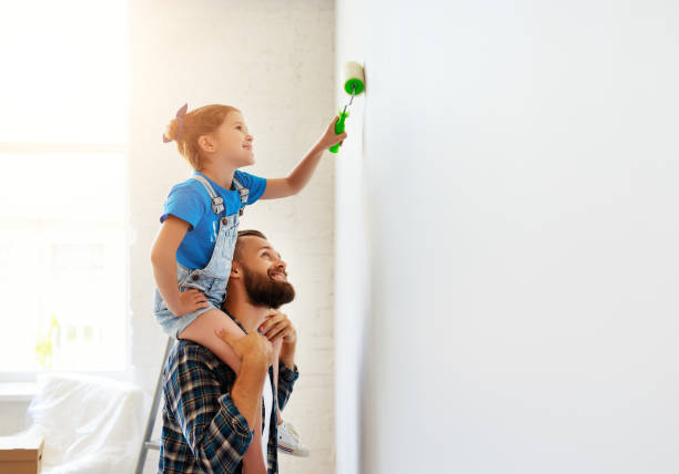 repair in apartment. happy family father and child daughter paints wall - female house painter home decorator paintbrush imagens e fotografias de stock