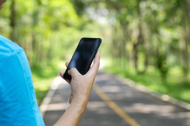 istock Man using smartphone on a road in the park 1181136476