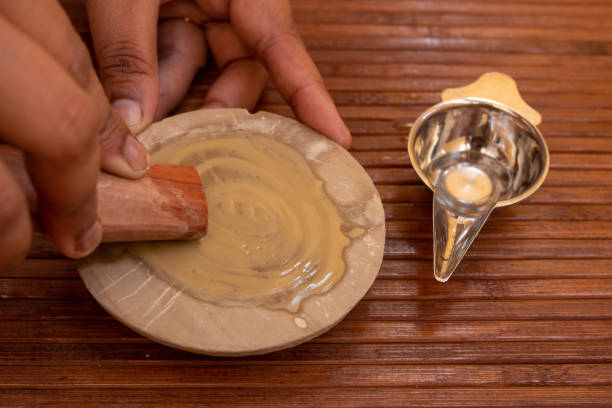 Sandalwood paste extraction from sandalwood using a stone and water Extraction of sandalwood paste from the sandalwood using a stone and adding water. sandalwood stock pictures, royalty-free photos & images