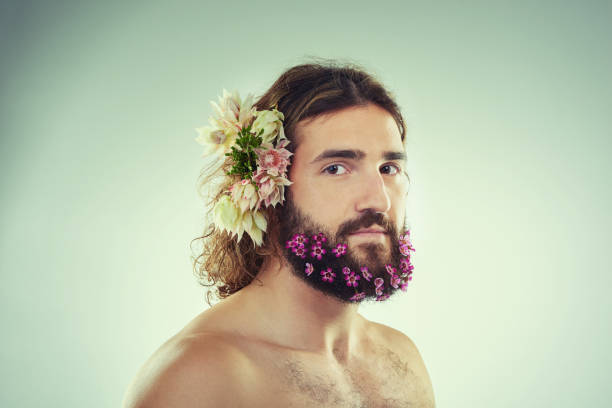 My manhood is defined by me Studio shot of a handsome young man with flowers in his beard man flower stock pictures, royalty-free photos & images