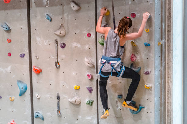 adolescente que escala na parede de escalada - climbing wall rock climbing holding reaching - fotografias e filmes do acervo