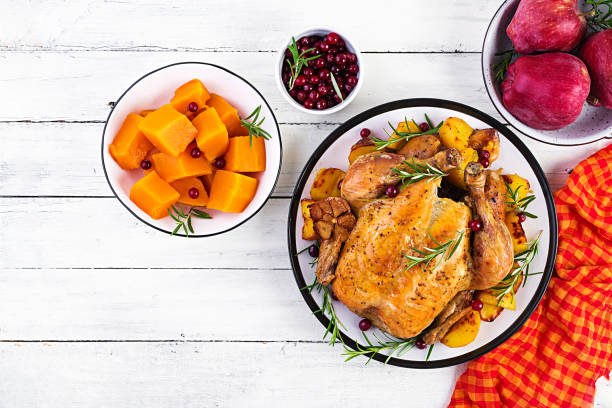 pavo asado adornado con arándanos en una mesa de estilo rústico decorada hoja de otoño. día de acción de gracias. pollo al horno. vista superior - thanksgiving table setting autumn fotografías e imágenes de stock