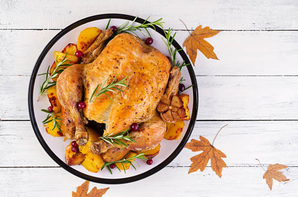 istock Roasted turkey garnished with cranberries on a rustic style table decorated  autumn leaf. Thanksgiving Day. Baked chicken. Top view 1181141217