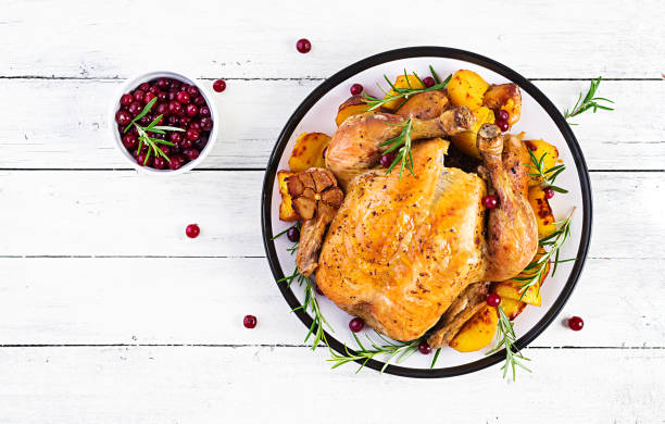 istock Roasted turkey garnished with cranberries on a rustic style table decorated  autumn leaf. Thanksgiving Day. Baked chicken. Top view 1181141228