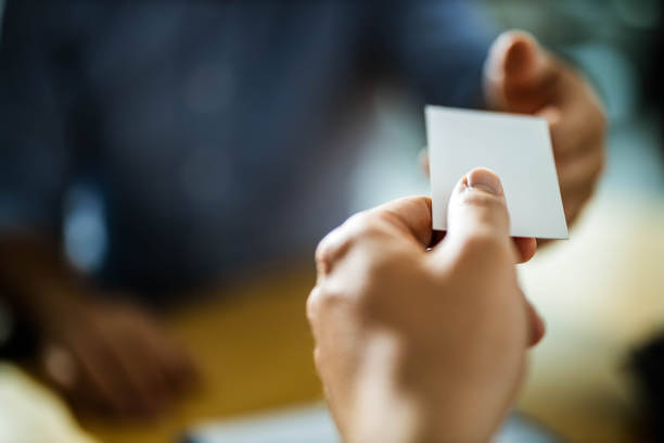 Close up of unrecognizable agent giving her business card to a client. Copy space.
