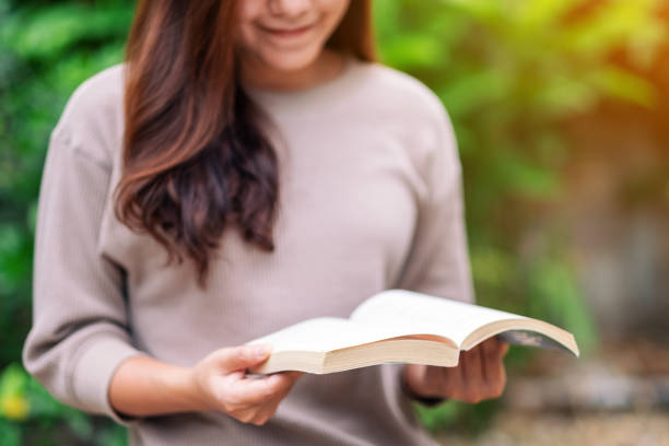 istock woman reading a book while sitting in the park 1181142985