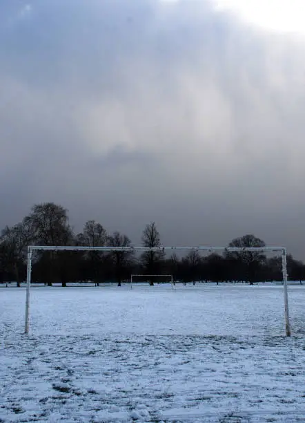 Frozen and deserted sports park in Clapham Common, London during the winter weather