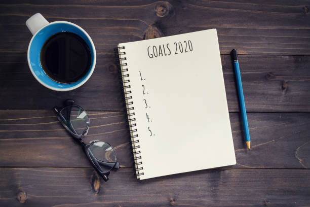 istock New Year goals, resolution or action plan 2020 concept. Office wood table with blank notepad, pencil, glasses, phone and cup of coffee. 1181144543