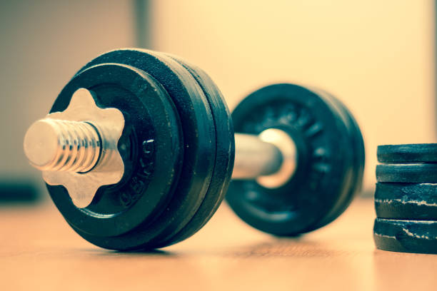 istock Bodybuilding concept: Barbell and weights on a gym floor 1181146962