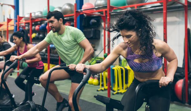istock Athletes doing air bike indoor 1181147256