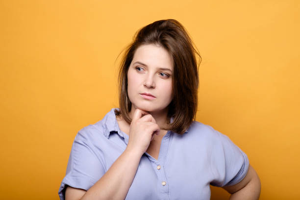 istock thoughtful emotional plus size model on a yellow background 1181147584