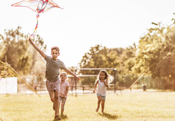 istock Kids running with kite in nature 1181151384
