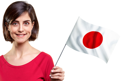 Young Woman Is Holding Japanese Flag On White Background Stock Photo