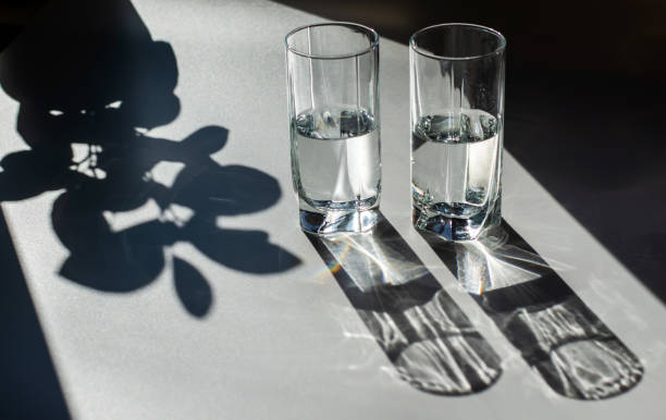 istock Two glasses of water. Bright light and contrasting shadows. 1181155552