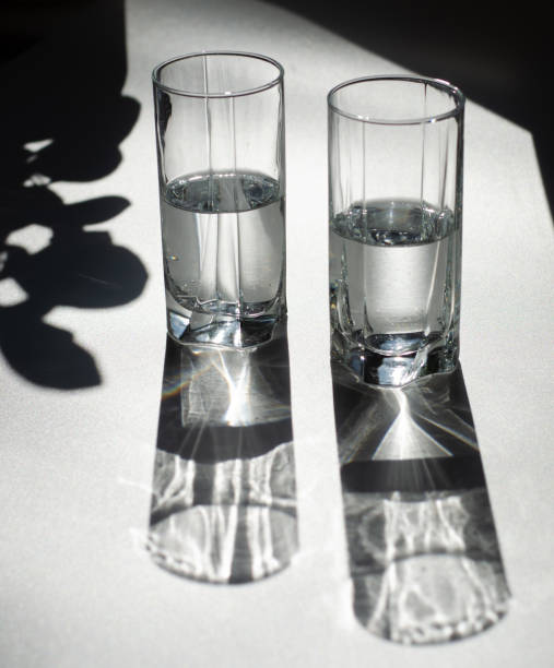 istock Two glasses of water. Bright light and contrasting shadows. 1181155555