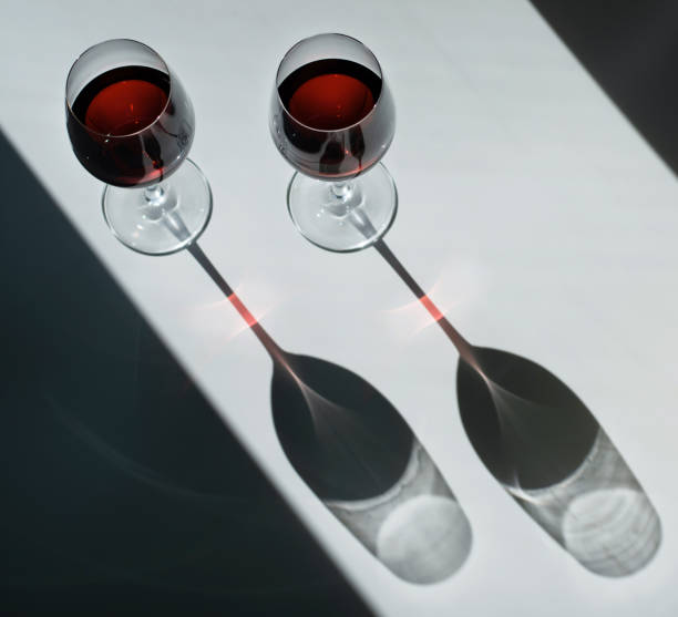 Two glasses of red wine on a plain background with bright light. Top view.. Beautiful life.