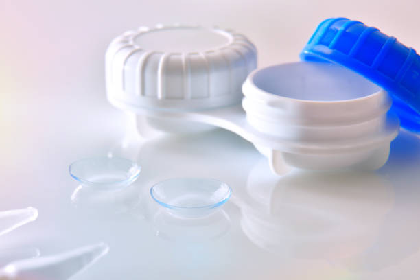 istock Contact lenses and case reflected on white glass table 1181156824